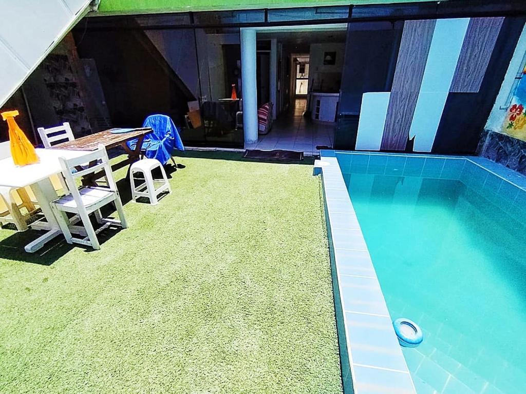 una piscina con tavolo e sedie accanto di Dpto. 1er piso 4 hab.Piscina Terraza a Punta Hermosa