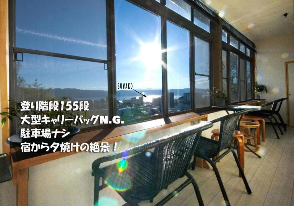 諏訪市にあるシャンブルドット畳のテーブルと景色を望む窓が備わる客室です。
