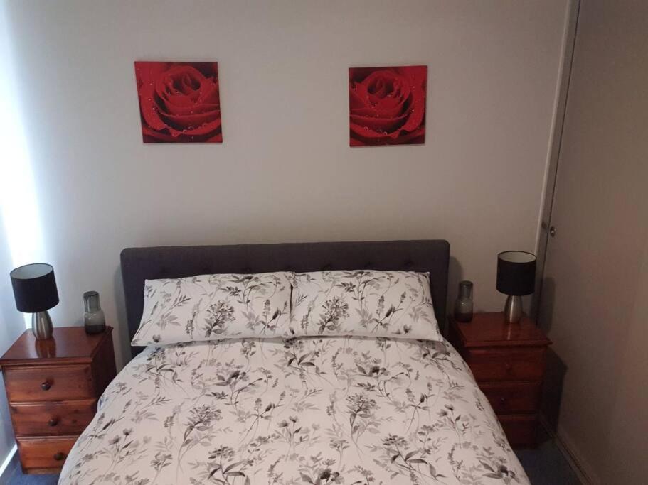 ein Schlafzimmer mit einem Bett mit zwei Bildern an der Wand in der Unterkunft Shore beats working in Port Sorell