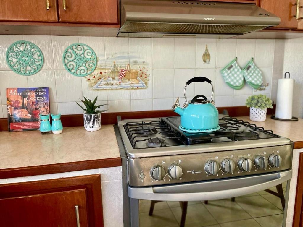 a blue tea kettle sitting on a stove in a kitchen at Departamento en el Área de Olas Altas in Mazatlán
