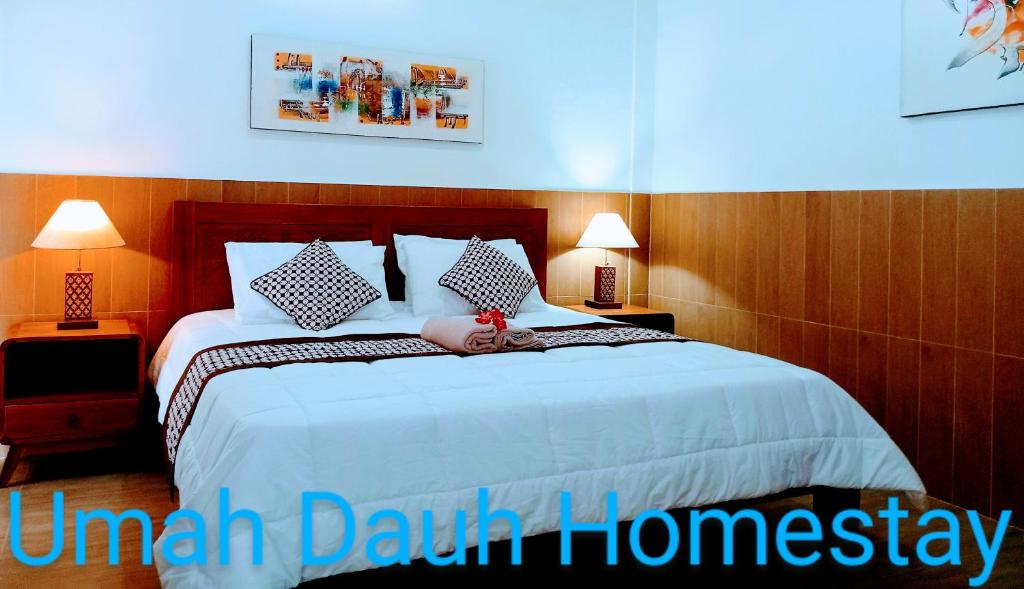 um quarto com uma cama grande e lençóis brancos em Umah Dauh Homestay em Ubud