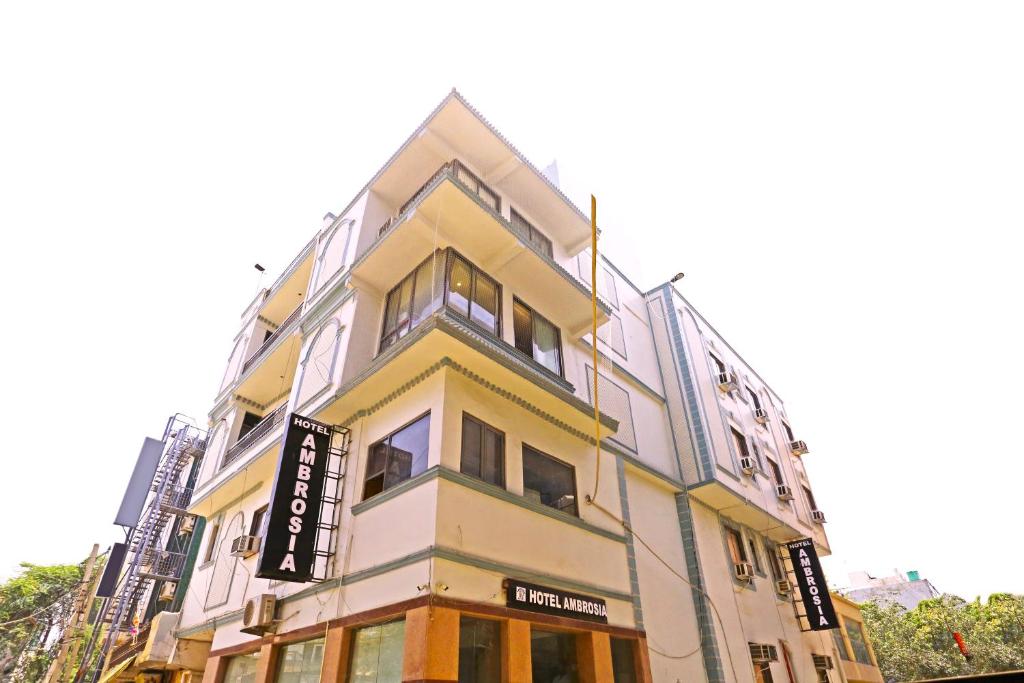 a yellow and white building with a sign on it at Hotel Ambrosia - A Boutique Hotel in New Delhi