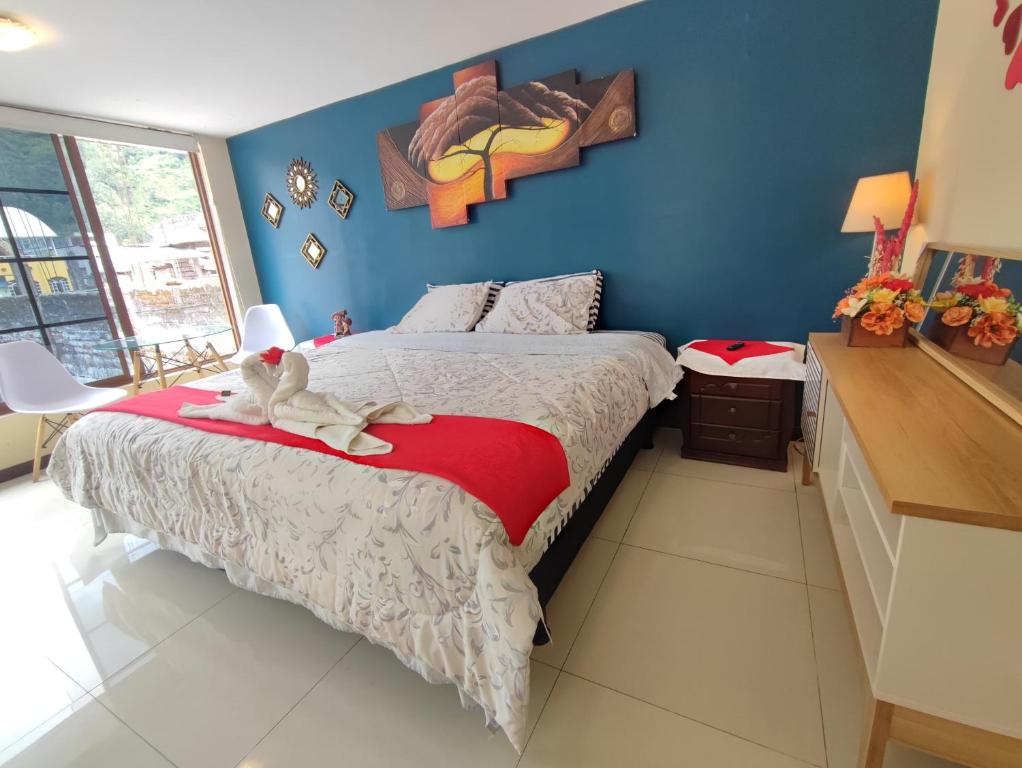 a bedroom with a bed with a stuffed animal on it at TURI Suite con Jacuzzi, centro de la ciudad in Baños