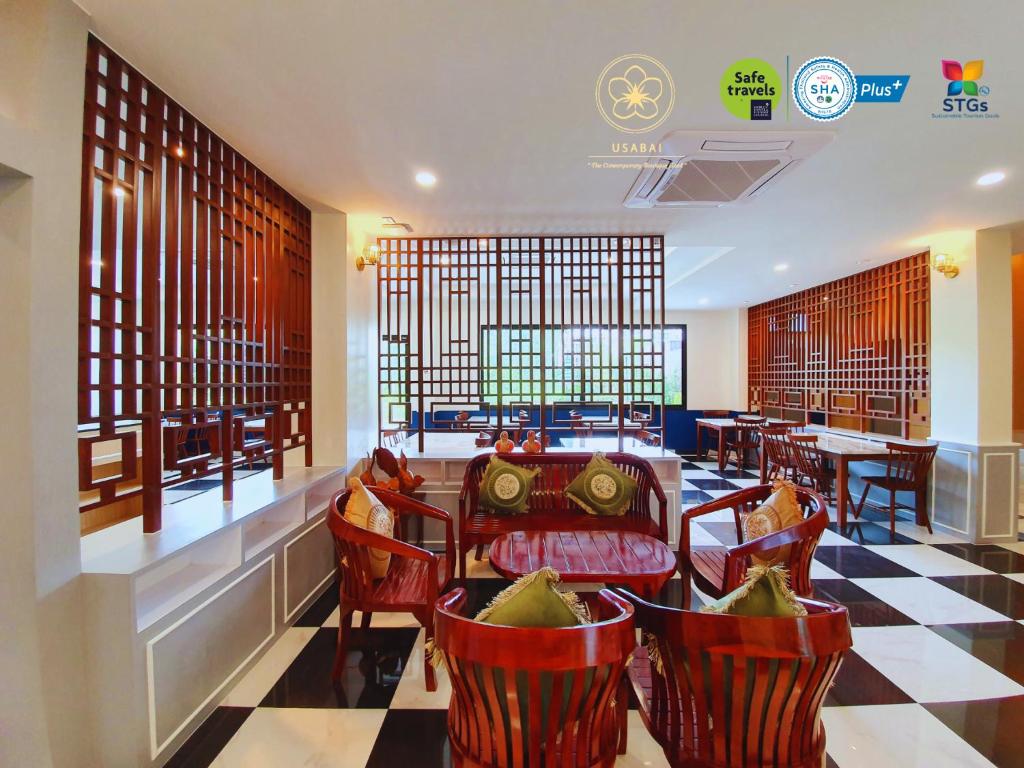 un restaurante con mesas y sillas rojas en una habitación en USABAI Riverside Boutique Hotel en Chanthaburi