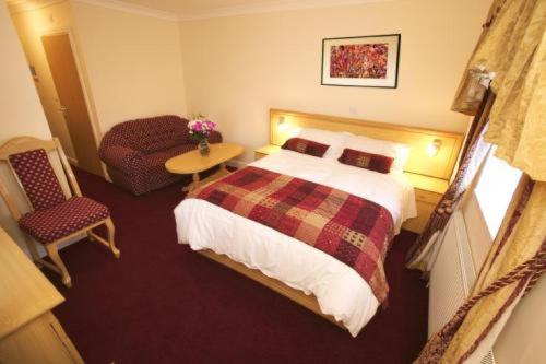 um quarto de hotel com uma cama e uma cadeira em Gateway Hotel em Newport