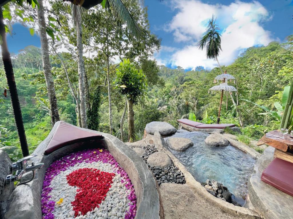 TampaksiringにあるRoyal Kemala Villa - Jungle View with Private Poolの花の飾り付きのリゾート内のプール