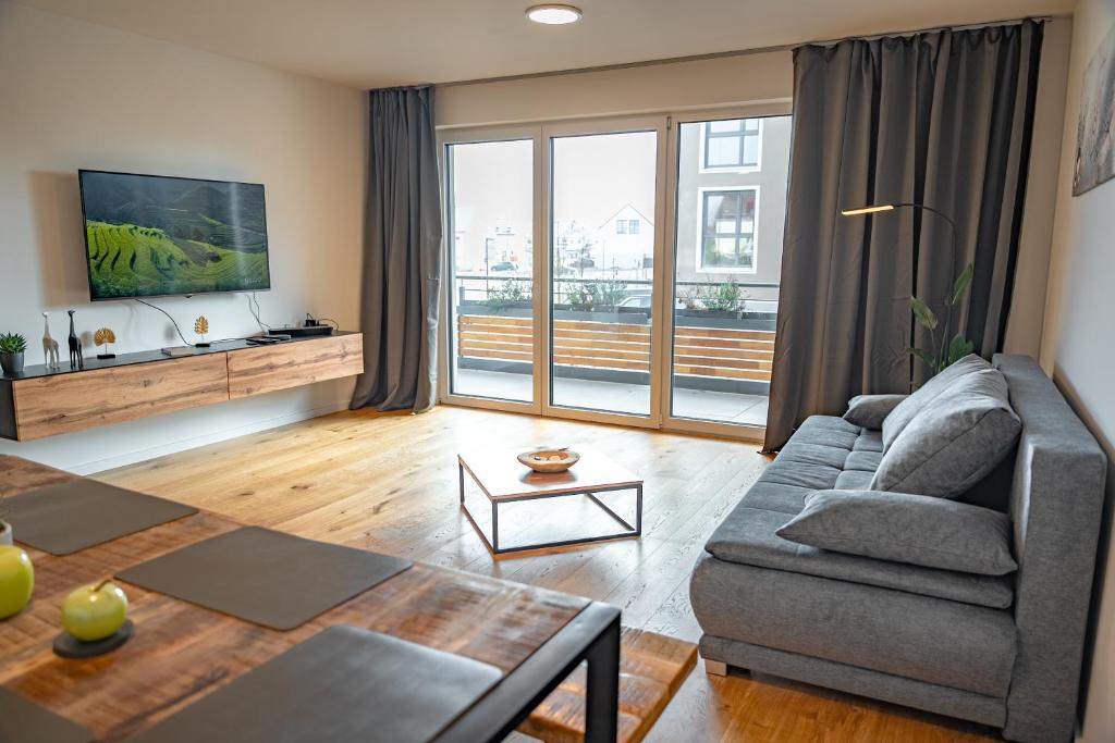 a living room with a couch and a table at ApartHome - 91m2 sonnig ruhig klimatisiert Balkon in Eching