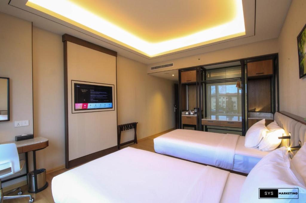 Postel nebo postele na pokoji v ubytování Sayarsan Hotel Yangon