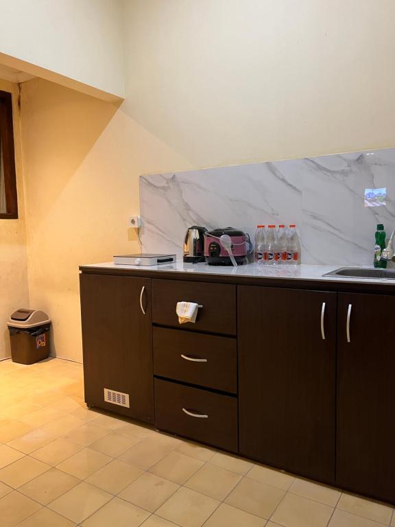 a kitchen with a counter top with a counter top at Attanaya Malioboro Suites Yogyakarta in Sentool