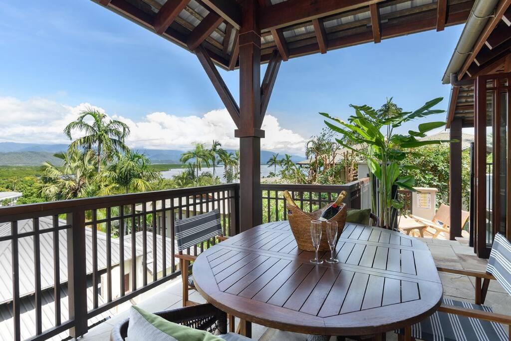 uma mesa numa varanda com vista para o oceano em Far Pavilion A - Stylish Villa with Tropical Views em Port Douglas