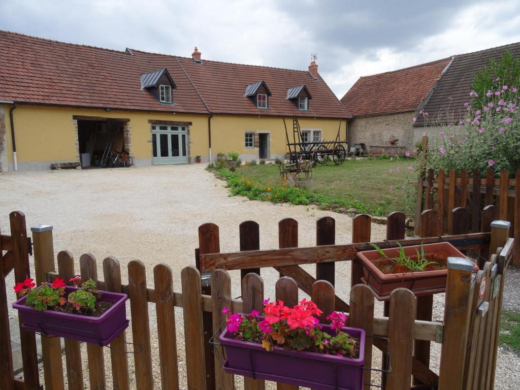 a wooden fence with flowers in pots on it at Datcha Bourguignonne, Chambres & Gîte in Maconge