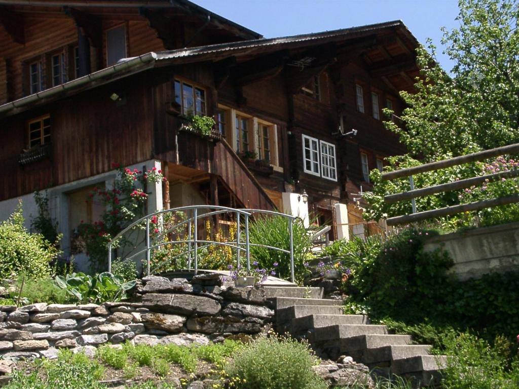 a wooden house with stairs leading up to it at Pension Staldacher in Hasliberg