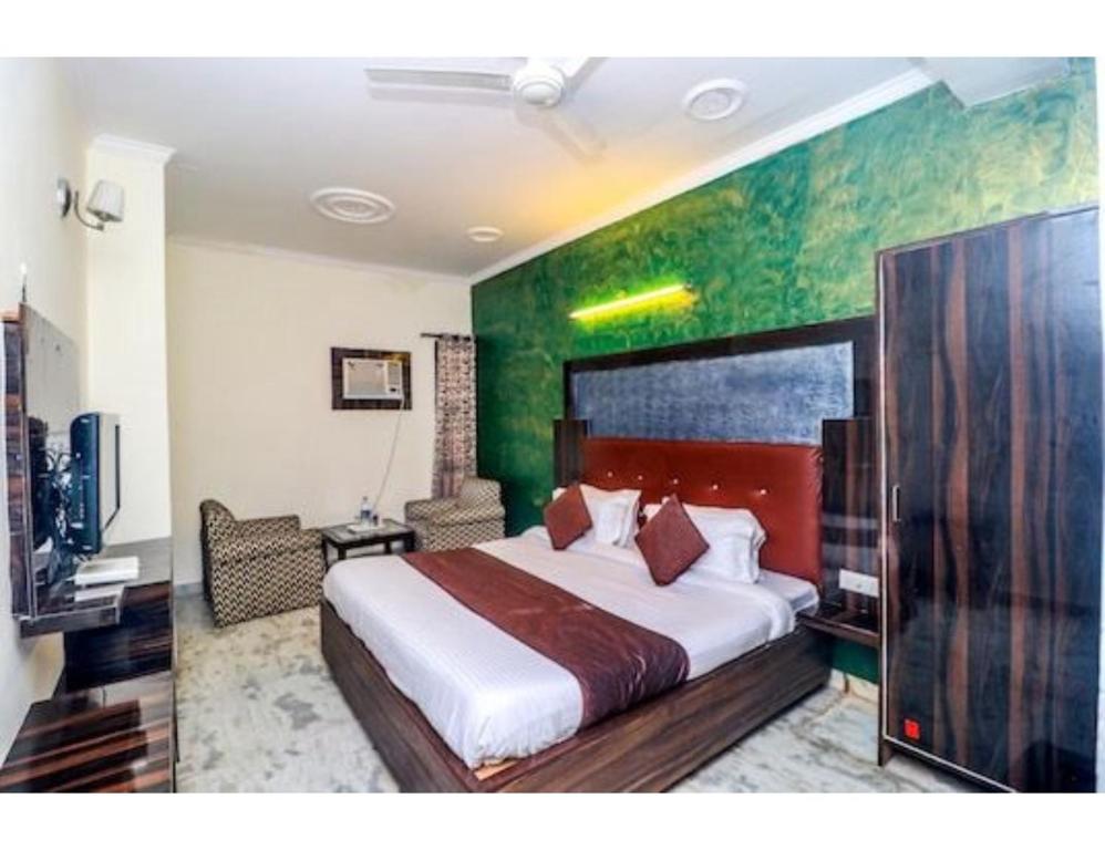 a bedroom with a large bed with a green wall at Hotel Shelton, Chandigarh in Chandīgarh