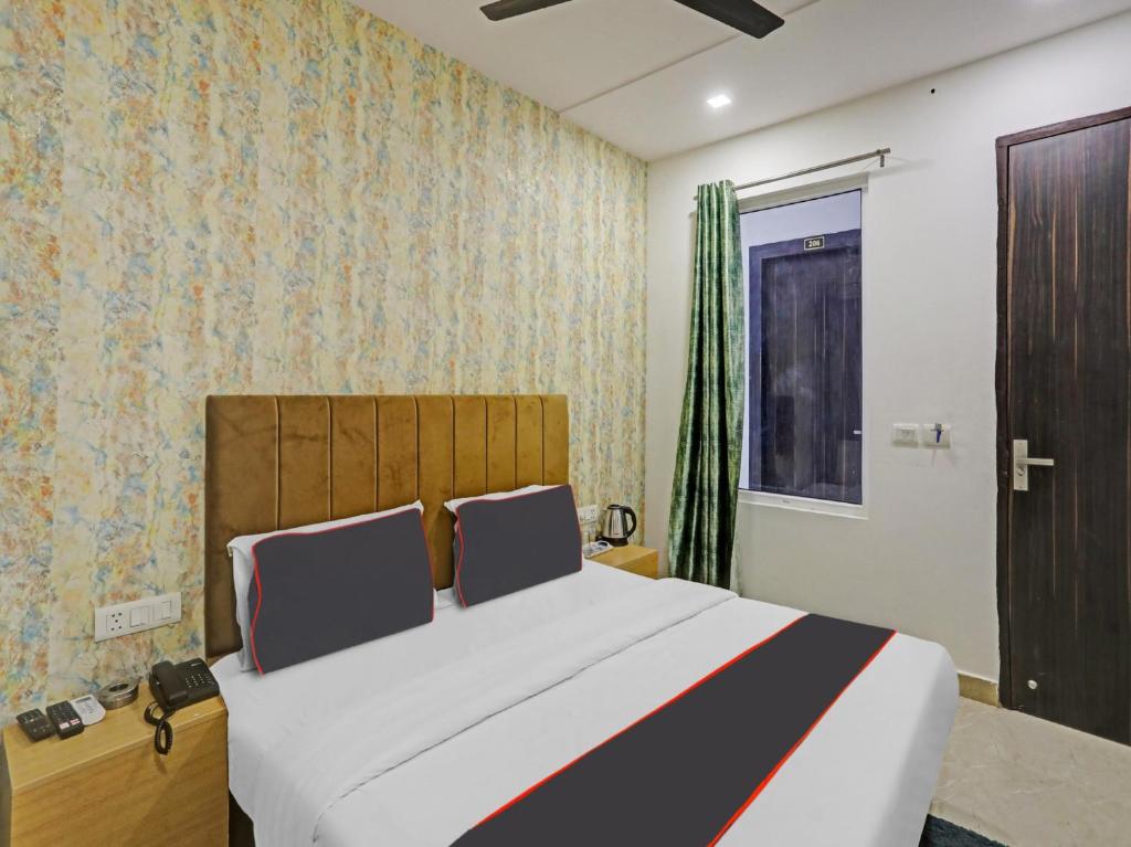 Un dormitorio con una cama grande y una ventana en OYO Flagship Cosmo Inn en Allahābād