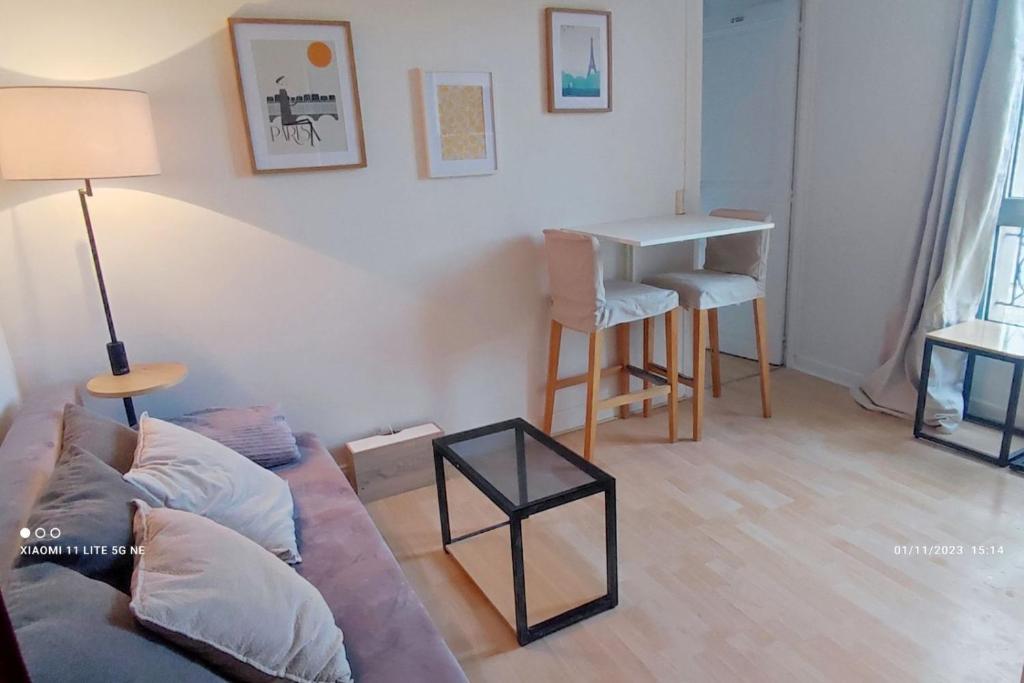 - un salon avec un canapé et une table dans l'établissement Appartement Cosy à 10min de la Villette & du Philharmonie Paris, à Le Pré-Saint-Gervais