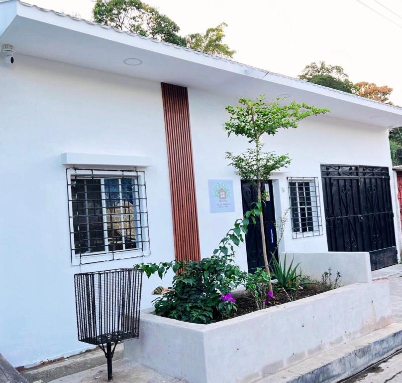 a white house with a red pole at Hostal Villa Marta in Santa Ana