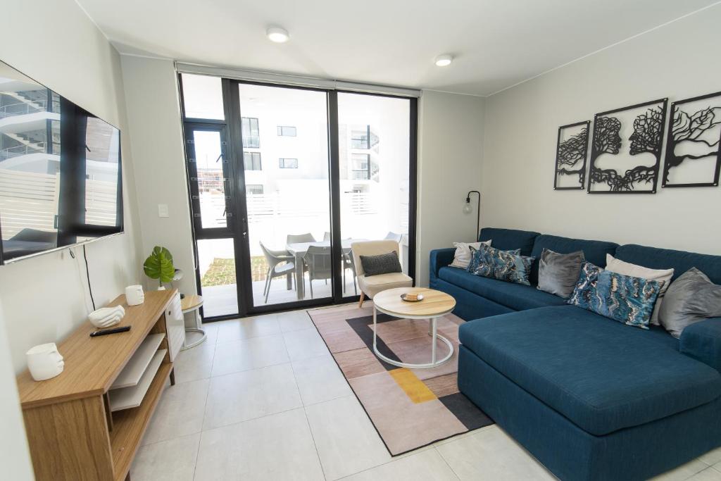 a living room with a blue couch and a table at First Class Apartment At Bella in Summerstrand