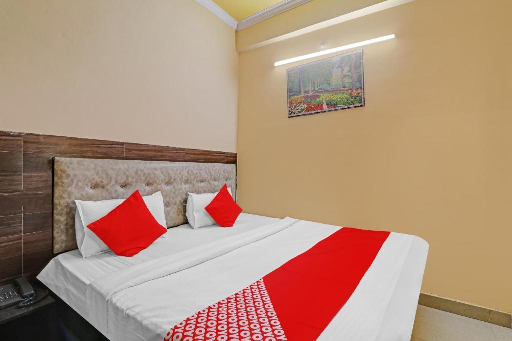 a bedroom with a bed with red and white pillows at OYO Flagship Hotel Four Square in Lucknow