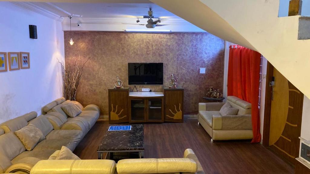 a living room with a couch and a tv at VISTAHOMES in Hyderabad
