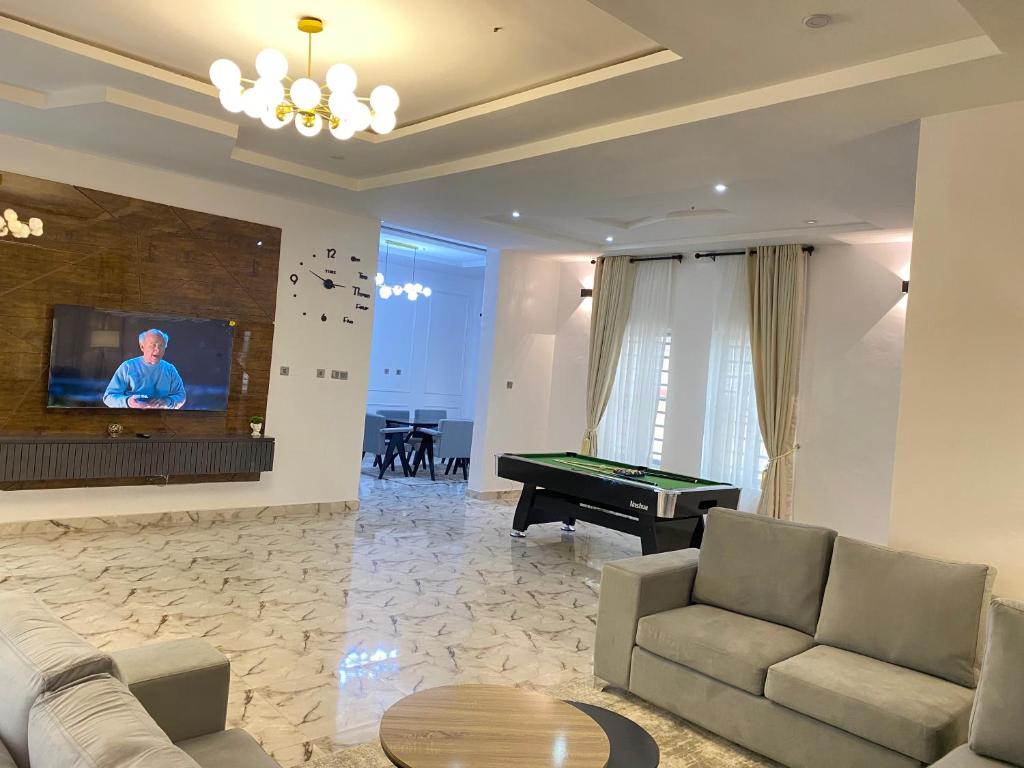 a living room with a pool table and a tv at Luxe Haven Lekki in Lekki