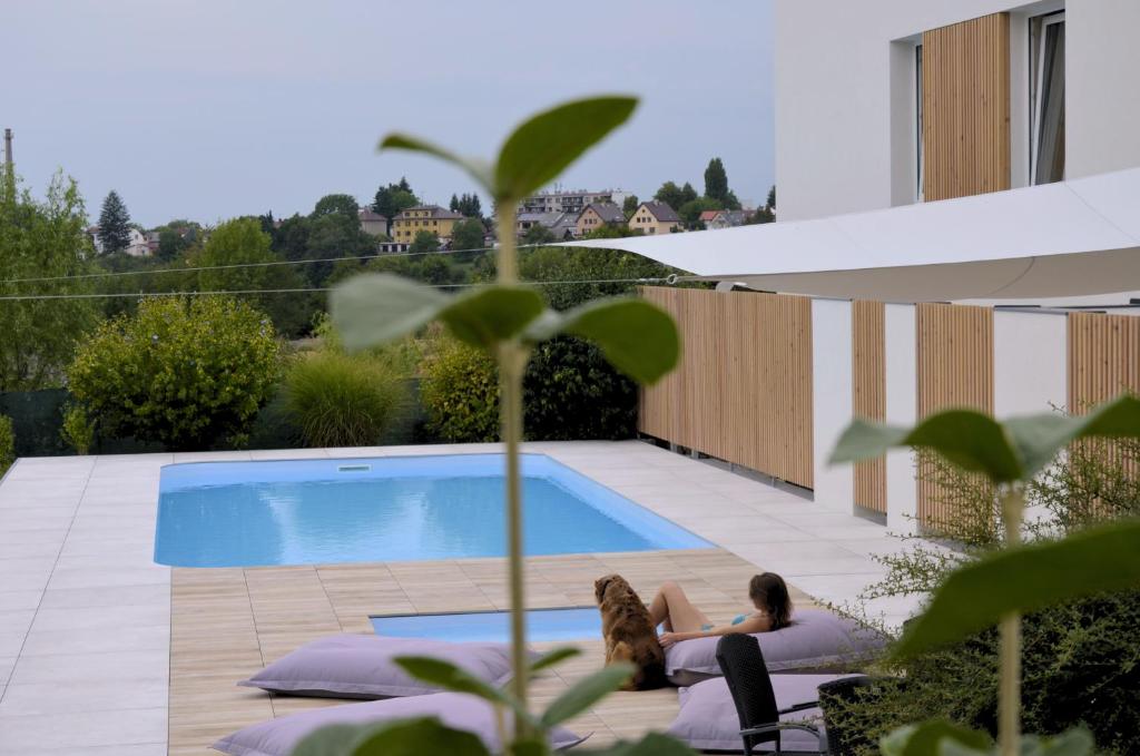 two women sitting on pillows next to a swimming pool at Studia a apartmány U Karla in Turnov