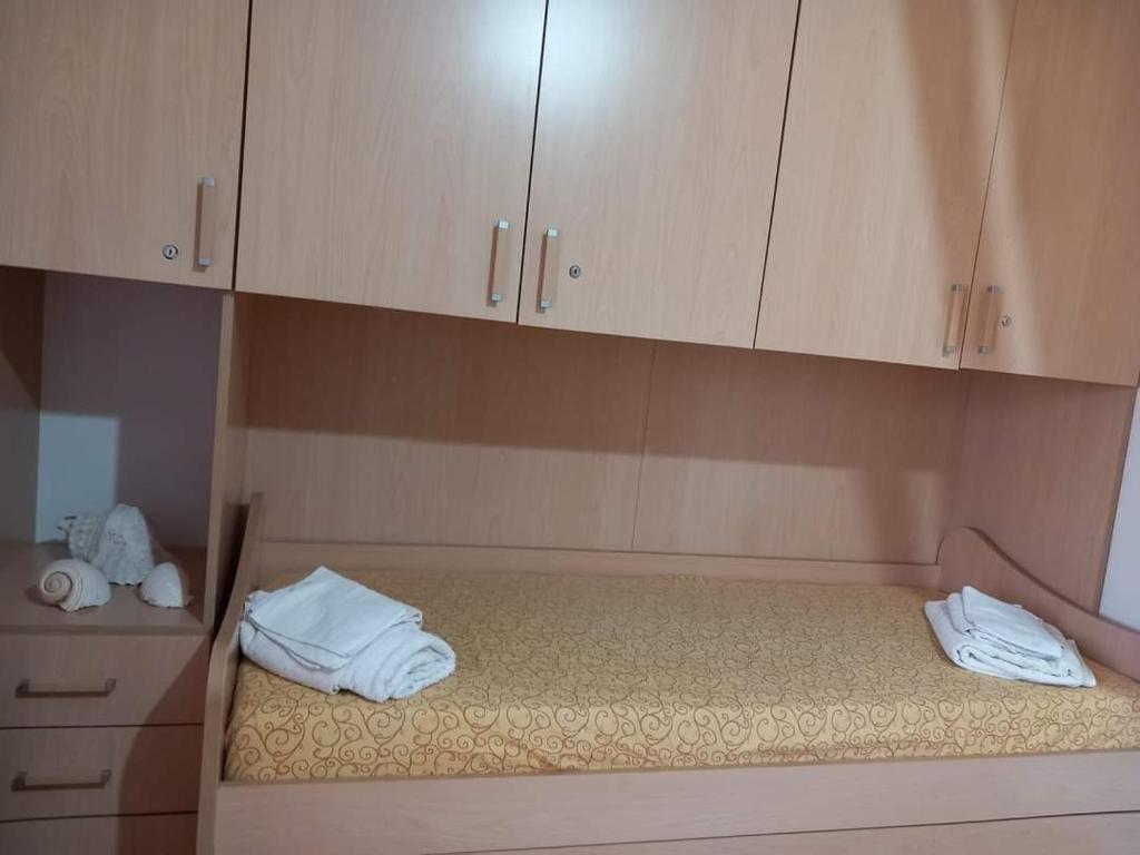 a room with a bed with white towels and cabinets at Lampedusa Low Prices in Lampedusa