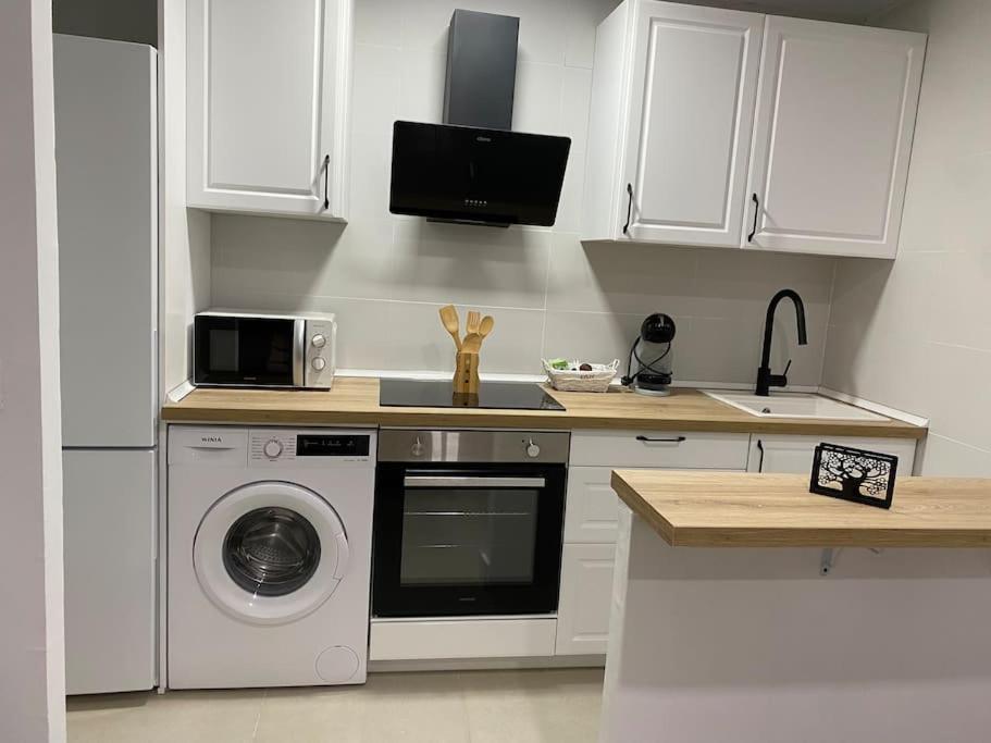 cocina con lavadora y microondas en Apartamento Baeza 4B, en Baeza