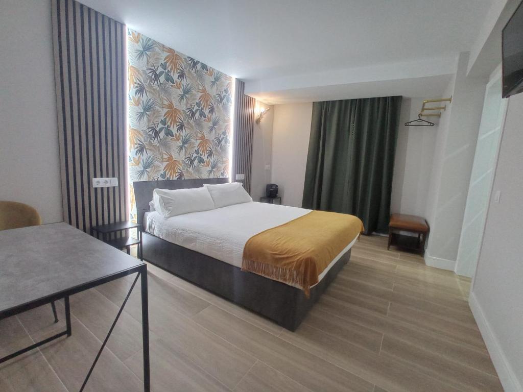Habitación de hotel con cama y ventana grande en Hostal Fronton, en Alcobendas