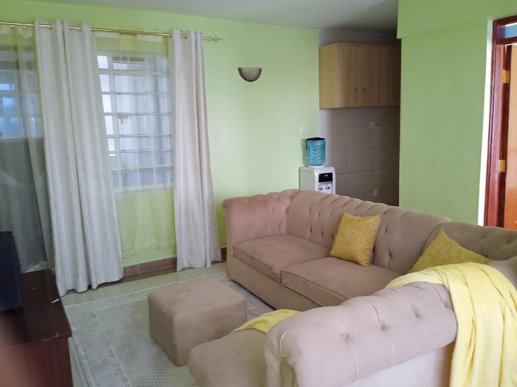 sala de estar con sofá y ventana en Kay homes, en Nairobi
