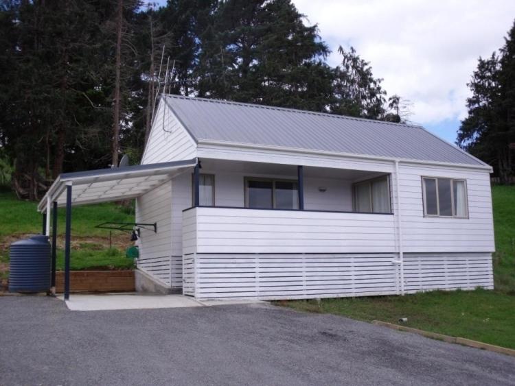 una casa blanca con garaje en un patio en Whangarei Holiday Houses, en Whangarei