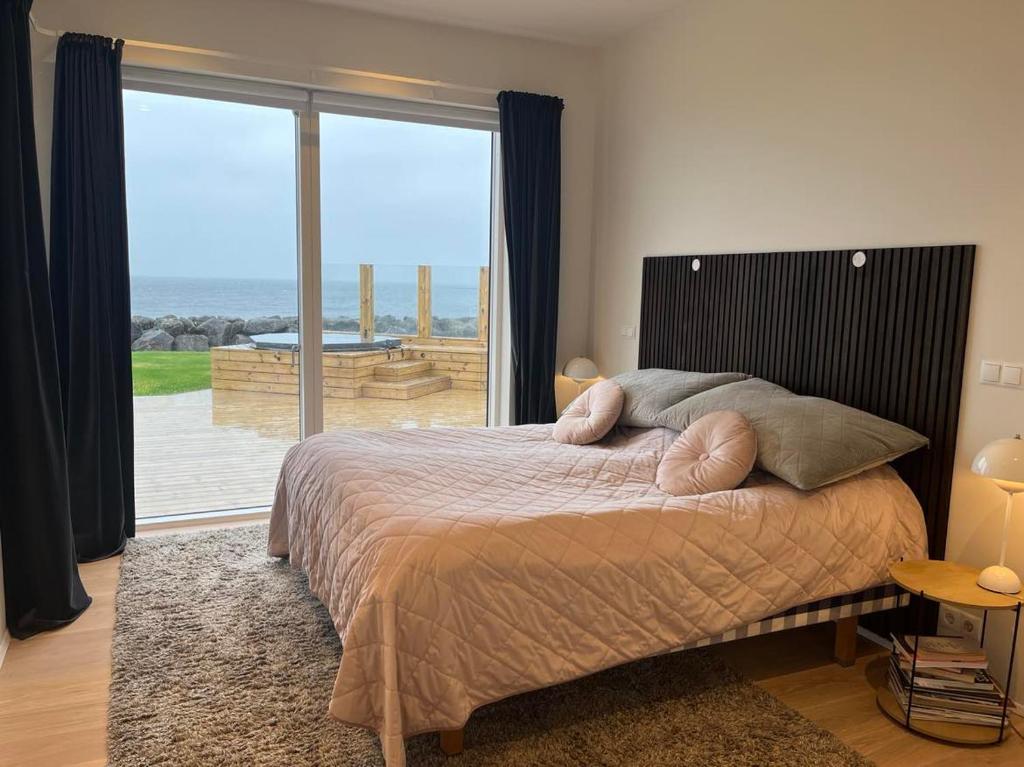 - une chambre avec un lit et une vue sur l'océan dans l'établissement Oceanfront & Aurora Dreamscape Villa, à Álftanes