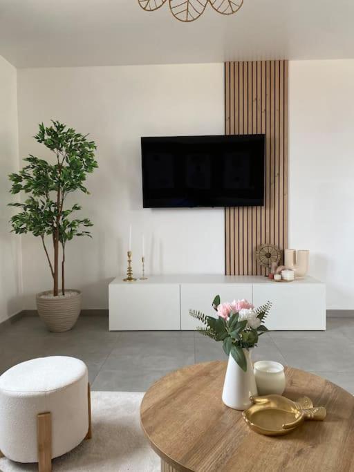 un salon avec un vase de fleurs sur une table dans l'établissement Maison au cœur de la campagne, à Saint-Romans