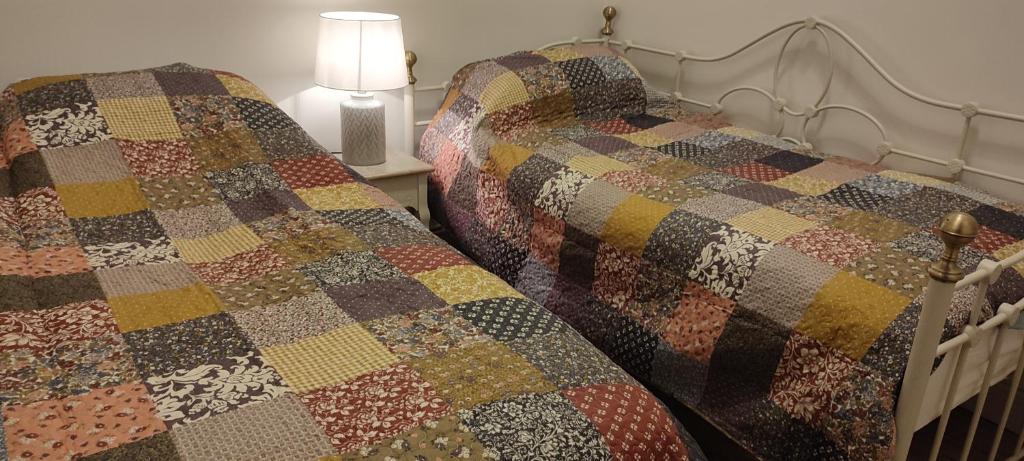 twee bedden in een kamer met een quilt bij The Old House at Belfield in Tralee