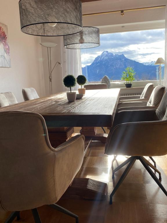 a dining room with a table and chairs with a mountain view at Villa Alpenblick in Füssen