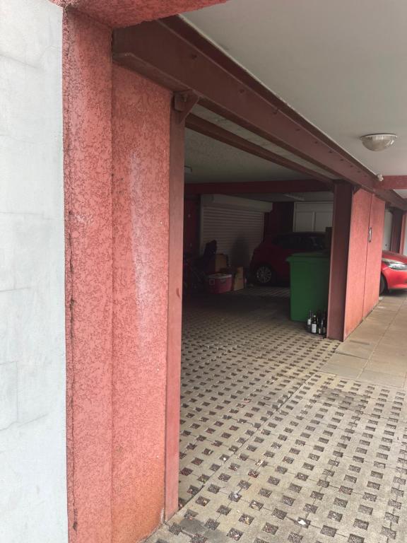 a garage with pink walls and a tile floor at CASA COLIVING avec chambre salle de bain individuelles privatives in Saint-Pierre