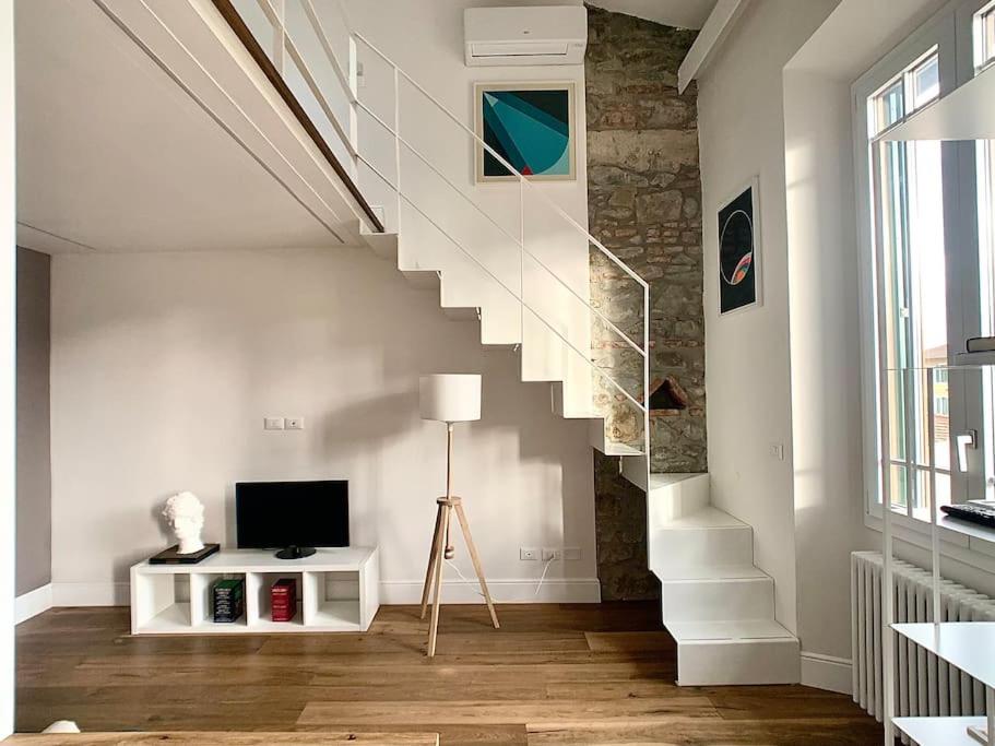 uma sala de estar com uma escada e uma televisão em Minimal Studio w/ balcony in DT. Quiet, Bright 2BD em Florença