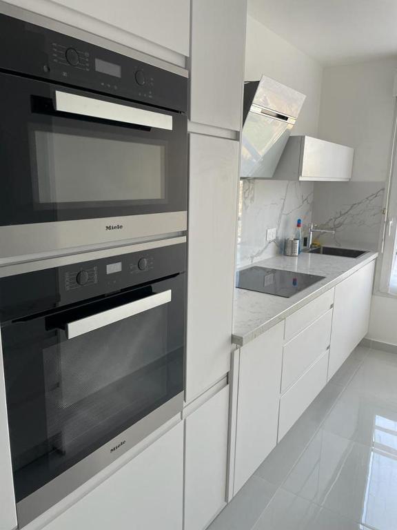 La cuisine est équipée d'un four noir et d'un évier. dans l'établissement Apparemment colombes, à Colombes