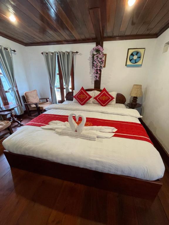 una camera da letto con un letto con due cigni al centro di Ouis NamKhan Place House a Luang Prabang