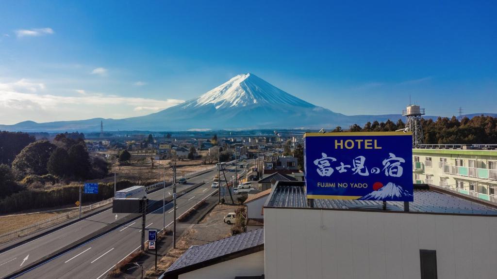 un cartello per un hotel con una montagna sullo sfondo di 富士見の宿 a Gotemba