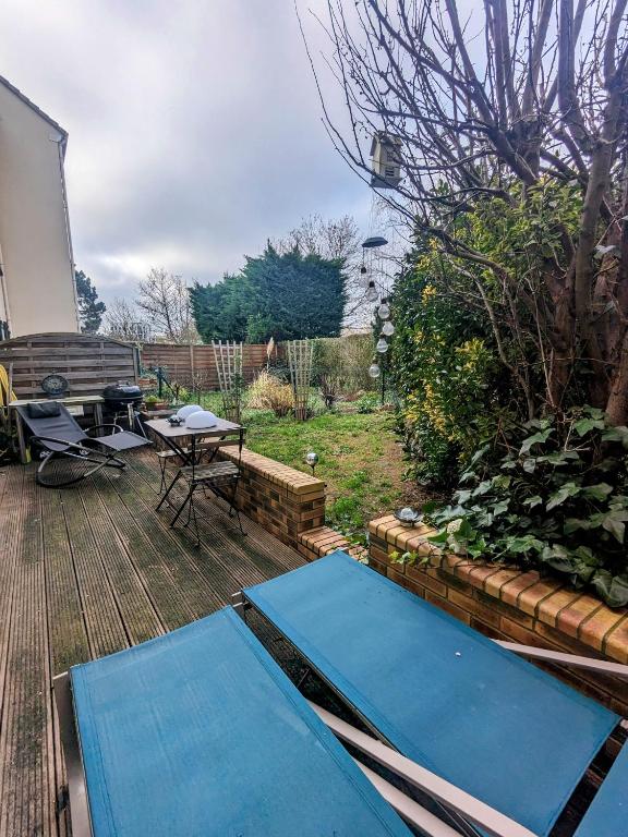 une terrasse en bois avec des tapis bleus dans l'établissement Appartement - jardin 3 pièces, à Carrières-sous-Poissy