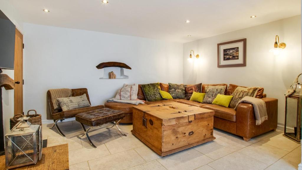ein Wohnzimmer mit einem Sofa und einem Tisch in der Unterkunft Swn Y Mor in Port-Eynon