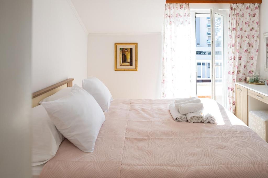 a white bed with white pillows and towels on it at Villa Ruza in Dubrovnik