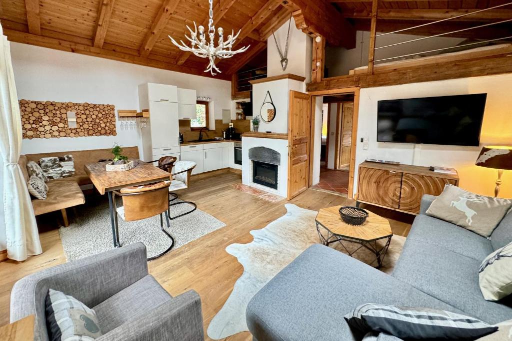 a living room with a couch and a dining room at CHALET BELLE KITZ by Belle Stay in Kitzbühel