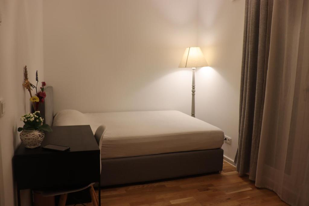 1 dormitorio con cama, escritorio y lámpara en Cosy room near Berlin and close to Tesla Factory in Brandenburg 