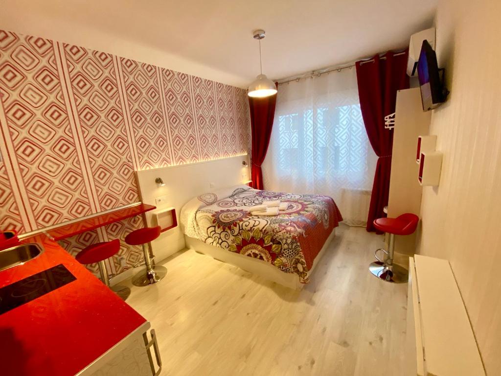 1 dormitorio con cama y pared roja en MuchoMadrid Apartments, en Madrid