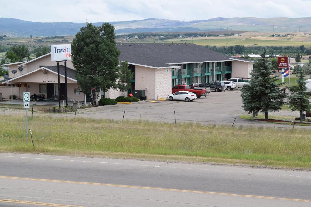 a hotel with cars parked in a parking lot at Traveler Inn Craig in Craig