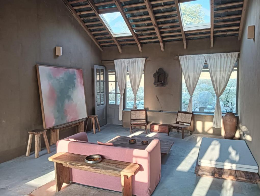 - un salon avec un canapé rose et une table dans l'établissement Pala Dharamshala - Mountain Cottage, à Dharamsala