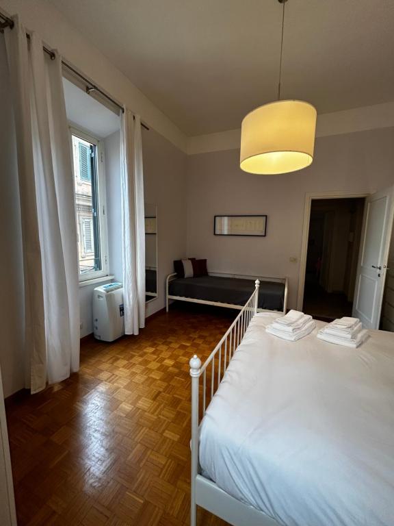 een slaapkamer met een wit bed en een bank bij Vatican Attic in Rome