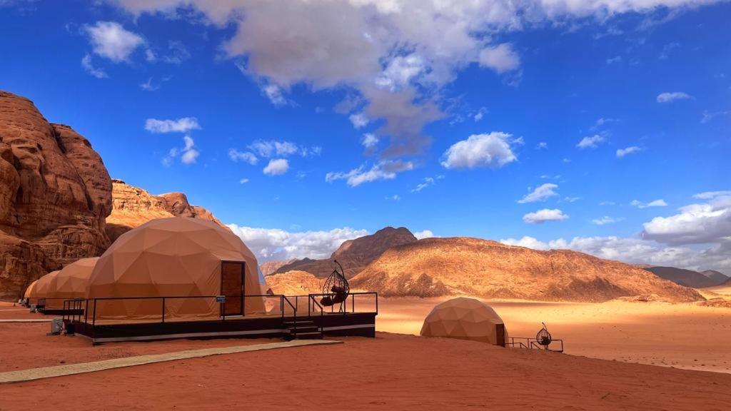 a group of tents in a desert with mountains at Montana Camp wadi rum in Wadi Rum