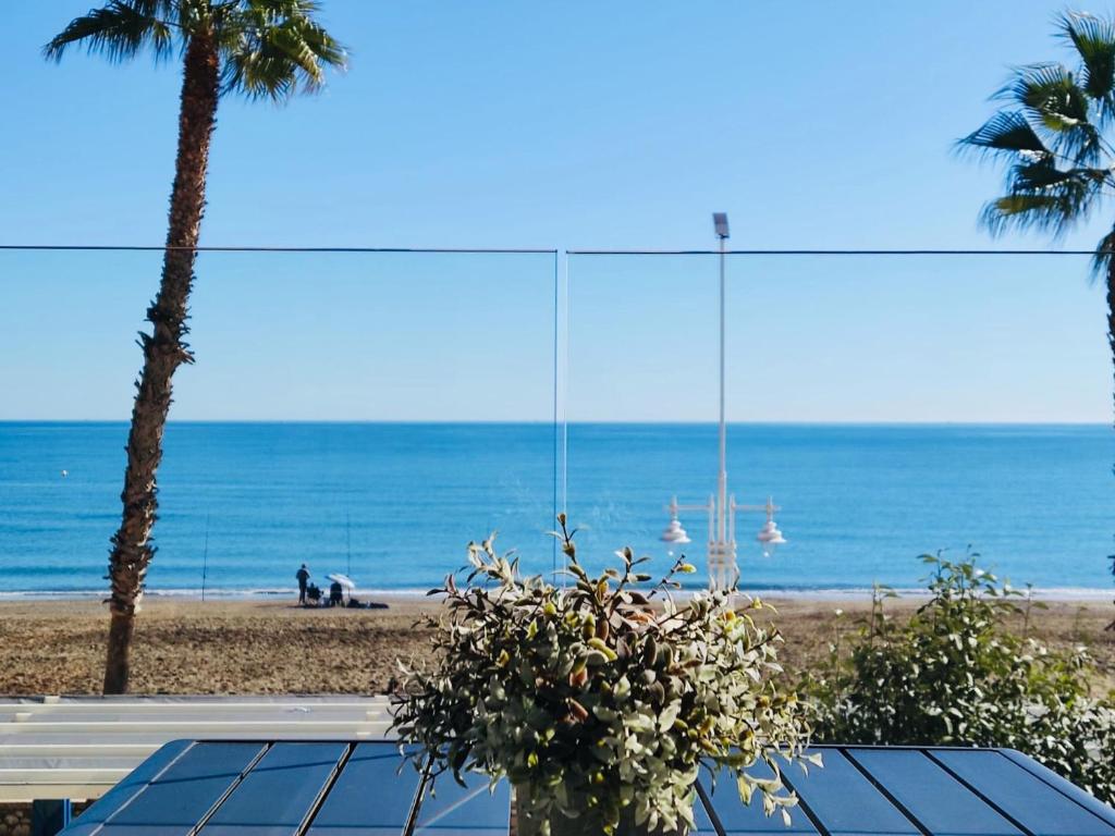 una playa con palmeras y vistas al océano en Gran vivienda de lujo frente al mar en Málaga